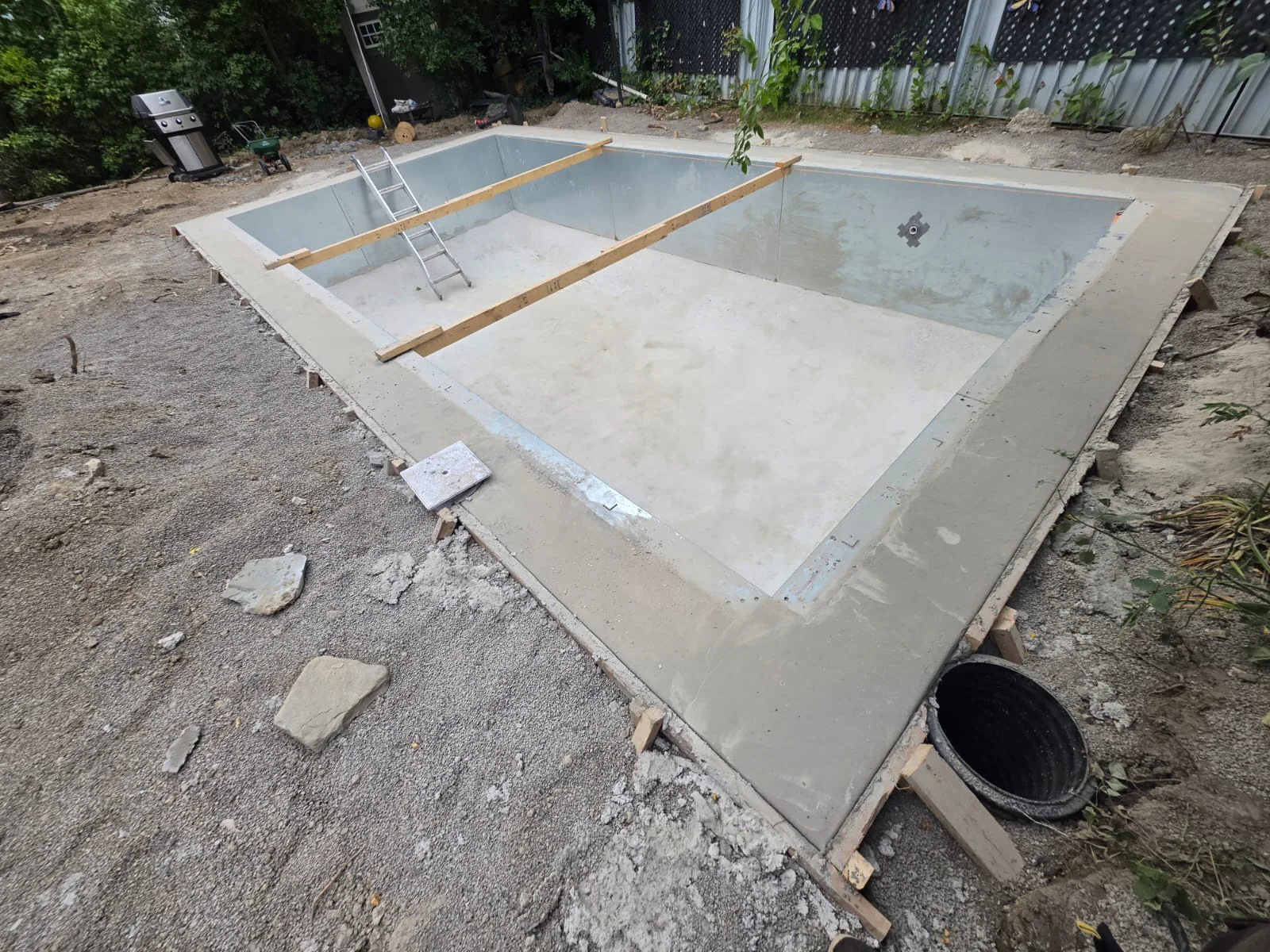 Pool shell and coping during preparation of the surrounding yard