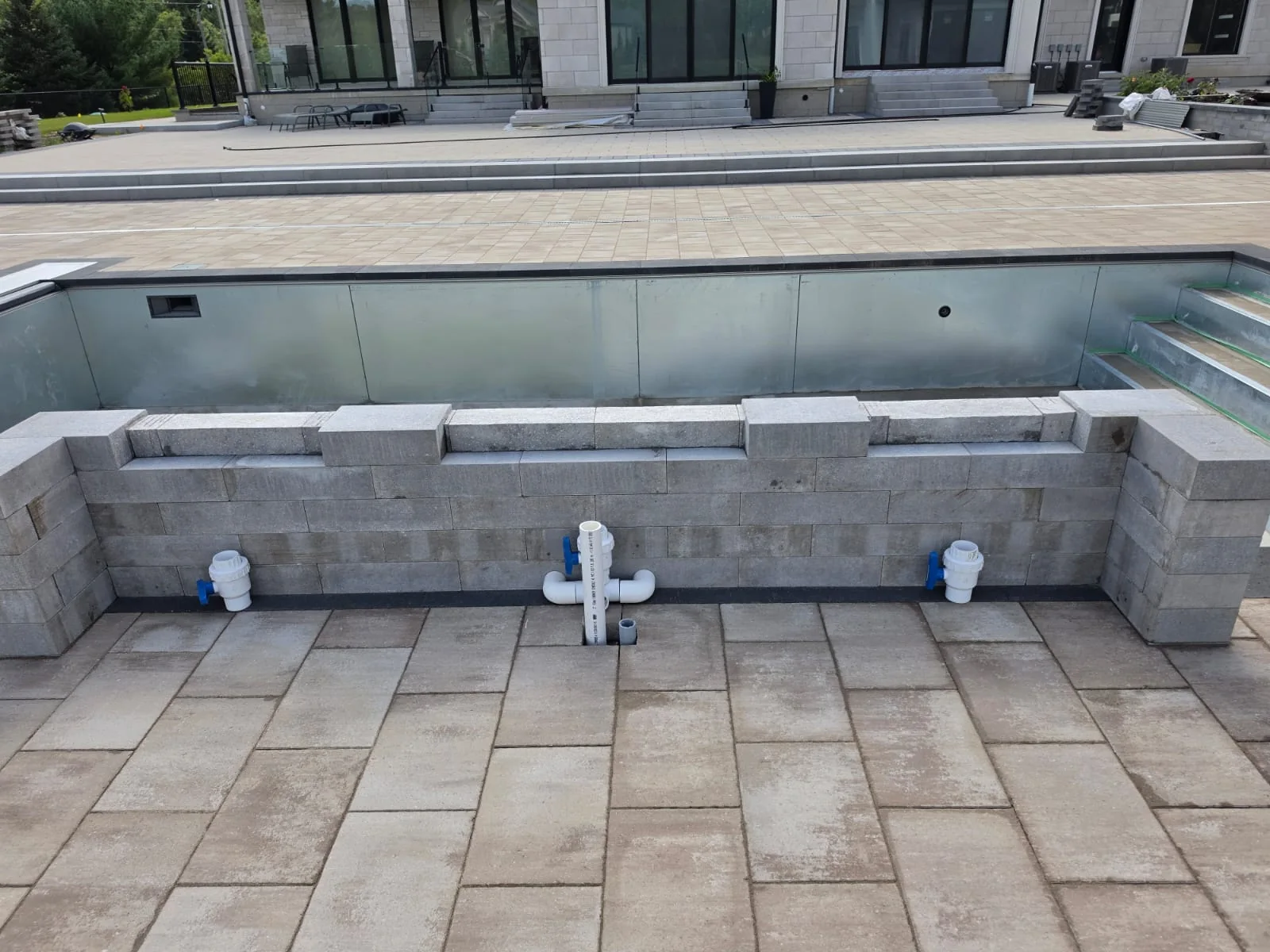 Raised poolside feature with exposed plumbing during installation