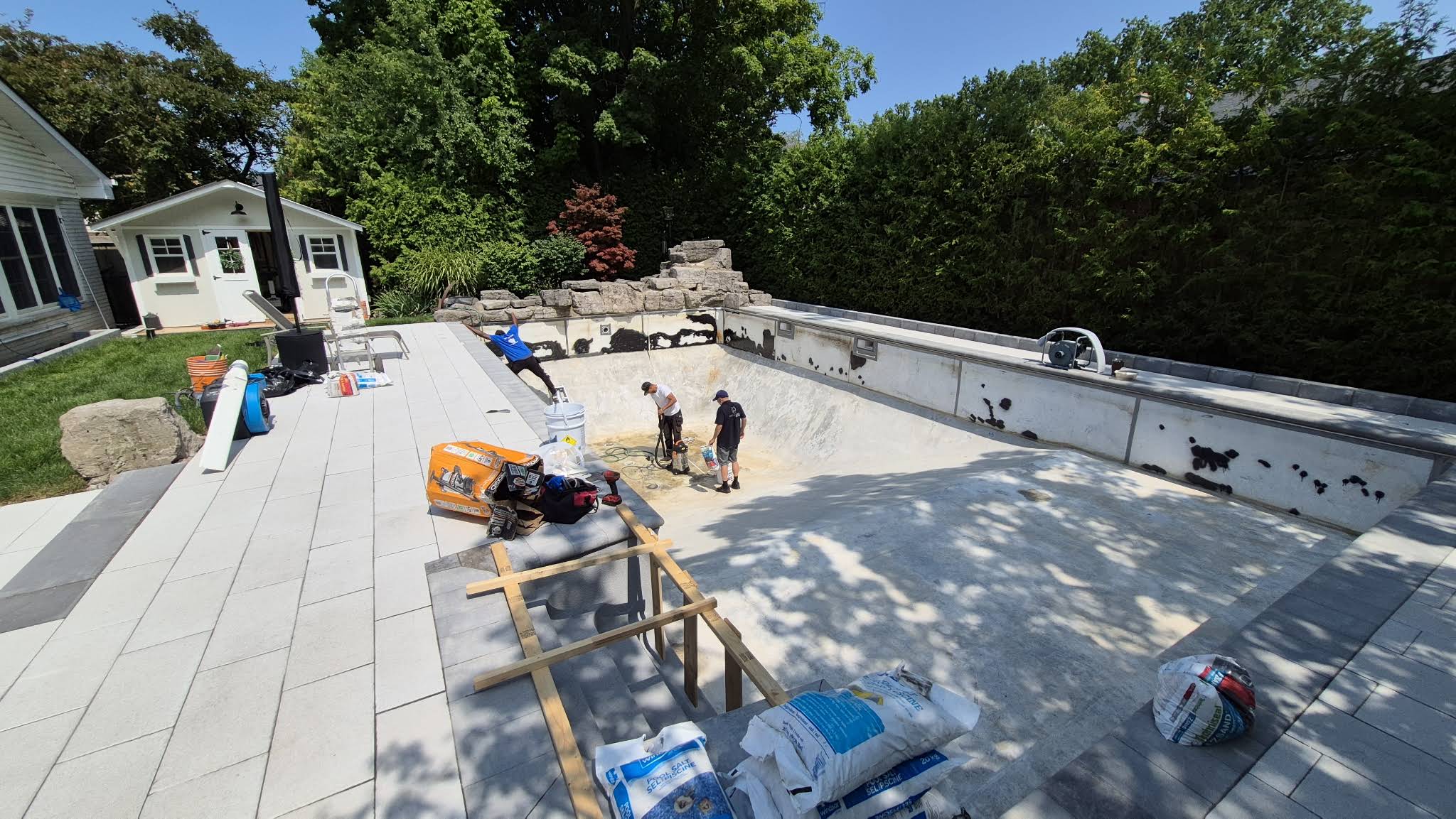 OPS crew working inside George’s empty pool with the old liner removed