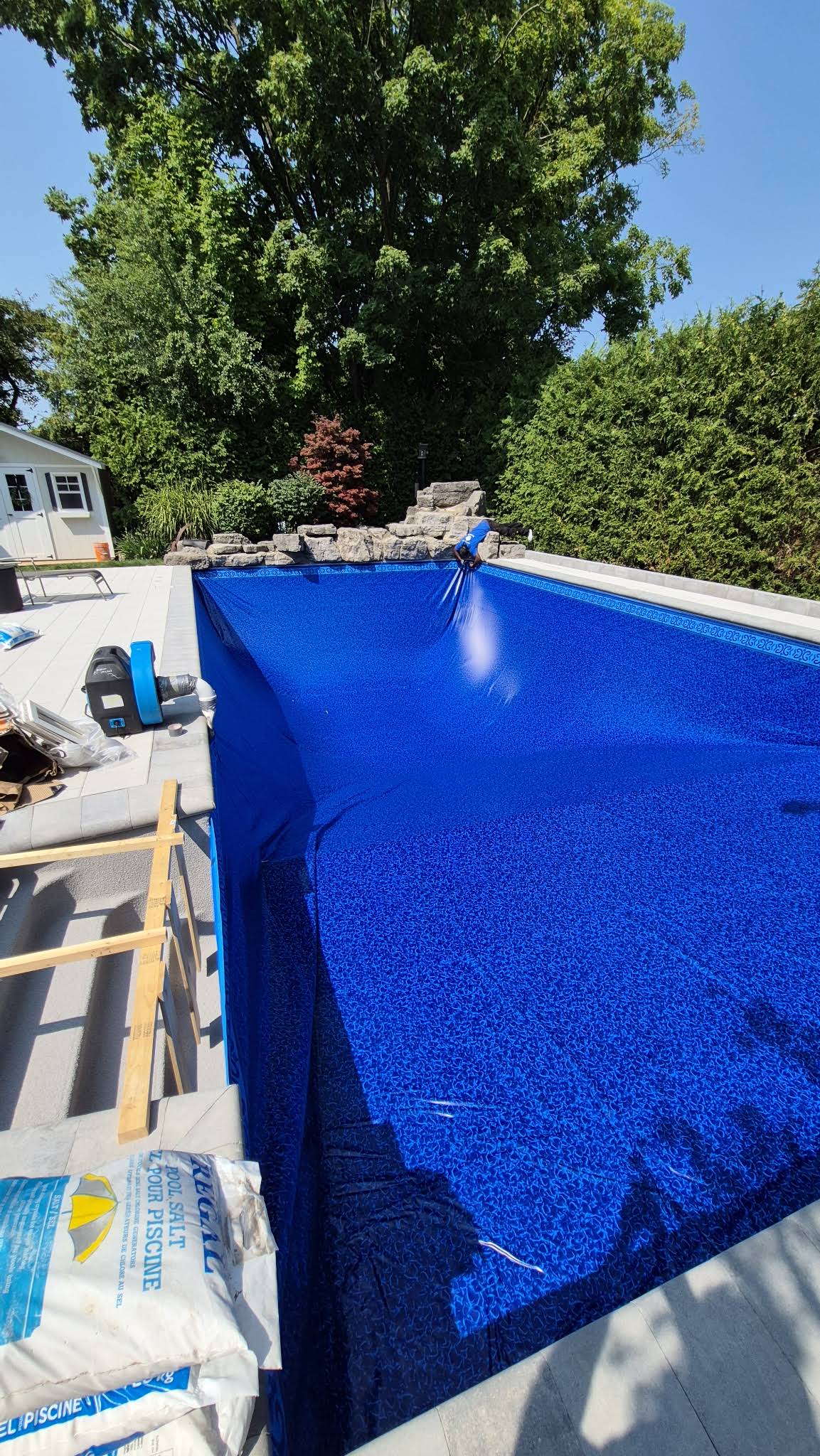 Portrait view of the fitted blue patterned pool liner before filling