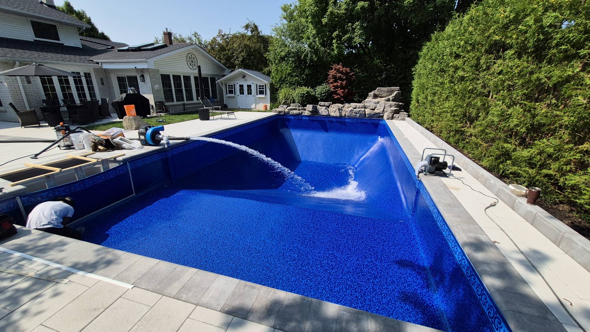 Water flowing into George’s pool after the new blue liner has been fitted